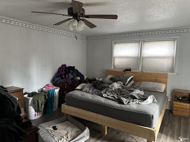 bedroom with ceiling fan, a textured ceiling, and wood finished floors