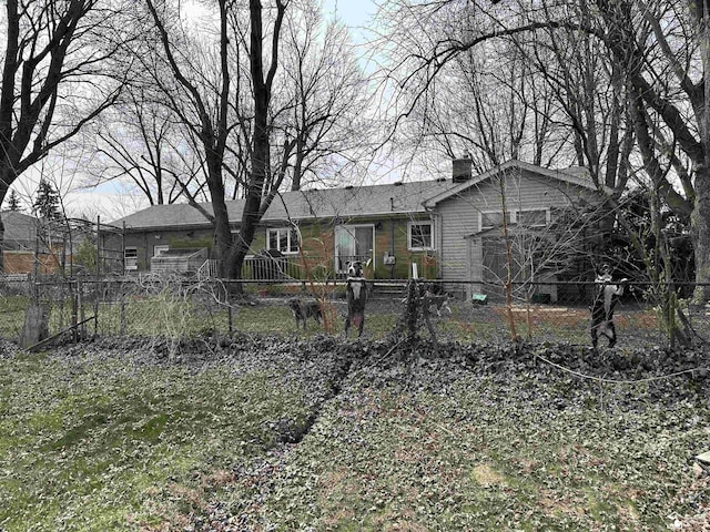 back of property with a chimney and fence private yard