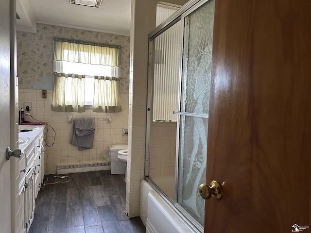 bathroom with tile walls, toilet, wood finished floors, and crown molding