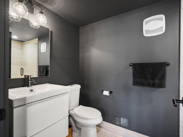 533 E Harrison Ave Unit 12, Royal Oak, MI 48067 - full bathroom with toilet, wood finished floors, vanity, visible vents, and a shower stall