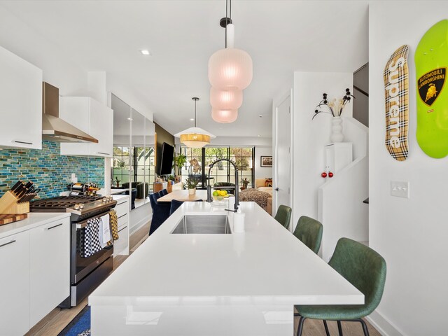 533 E Harrison Ave Unit 12, Royal Oak, MI 48067 - kitchen featuring stainless steel range with gas stovetop, a breakfast bar, white cabinetry, and a sink