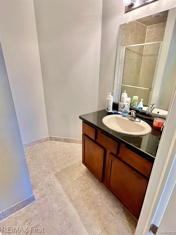 full bathroom featuring a shower stall, vanity, and tile patterned flooring