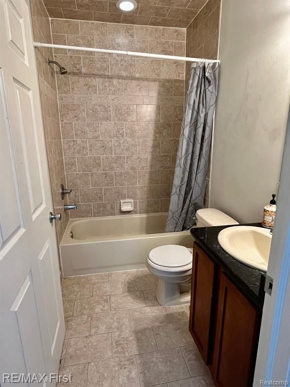 bathroom featuring shower / bath combo, vanity, and toilet