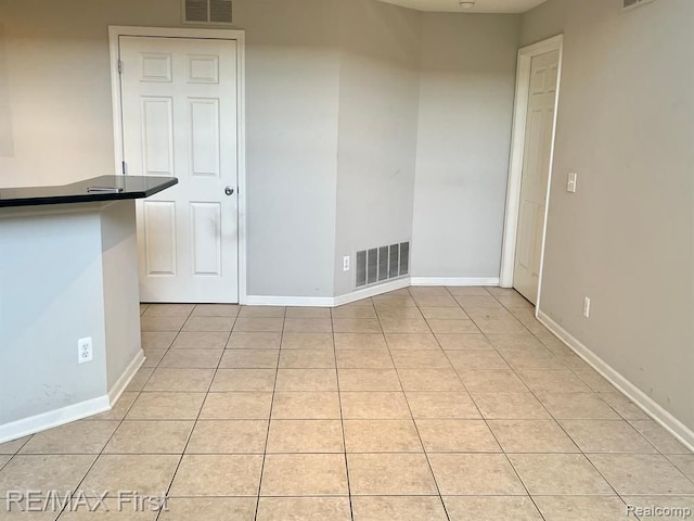 empty room featuring light tile patterned floors and baseboards