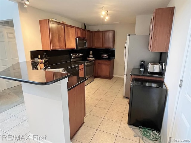 kitchen with electric range, stainless steel microwave, light tile patterned flooring, a peninsula, and brown cabinets