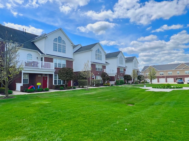 view of front of home with brick siding, a residential view, and a front yard