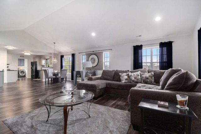 living room featuring washer / dryer, vaulted ceiling, dark wood-type flooring, healthy amount of natural light, and recessed lighting