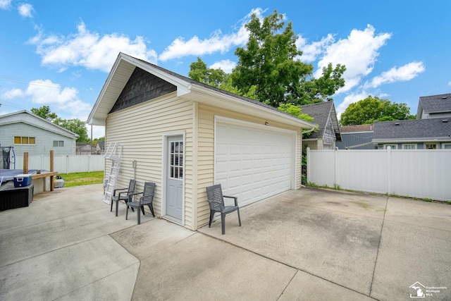 detached garage featuring fence