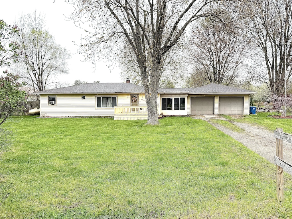 ranch-style house featuring a front lawn, driveway, and a garage