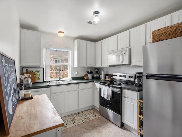 kitchen with white cabinetry, appliances with stainless steel finishes, visible vents, and a sink