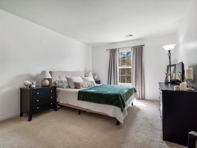 bedroom featuring visible vents and light colored carpet