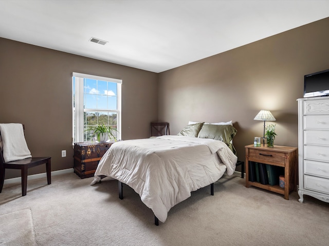 bedroom with baseboards, light carpet, and visible vents