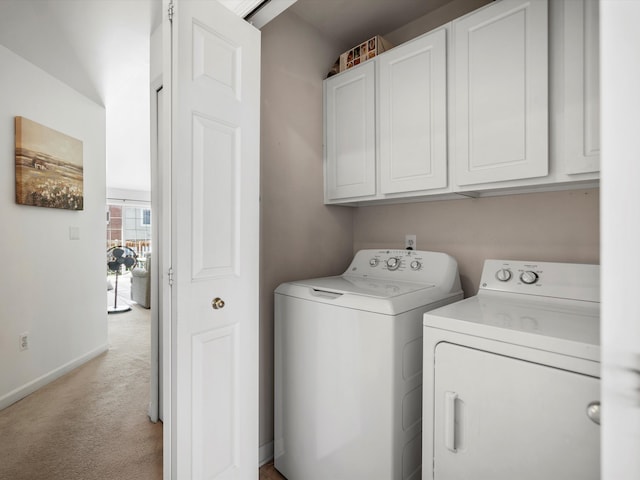 laundry room featuring washer and clothes dryer, light colored carpet, cabinet space, and baseboards