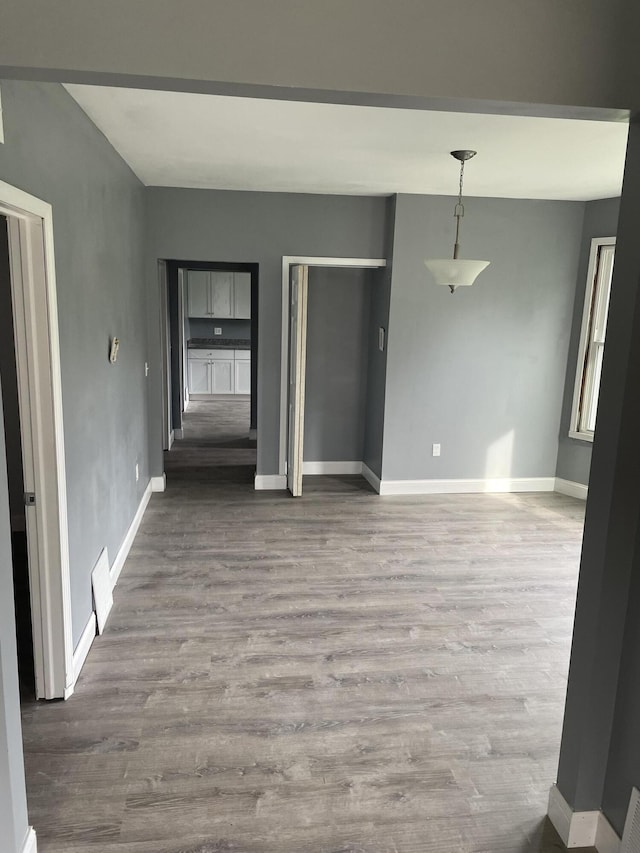 unfurnished room with wood finished floors and baseboards