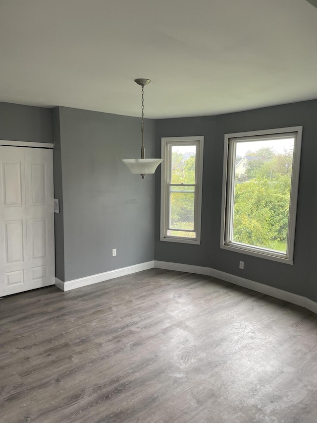 unfurnished room featuring dark wood-type flooring and baseboards