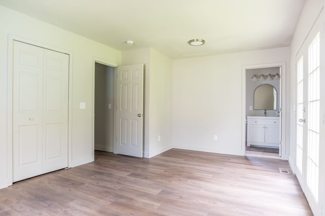 9114 Island Dr, Clay, MI 48001 - unfurnished bedroom with multiple windows, light wood-style floors, baseboards, and a closet