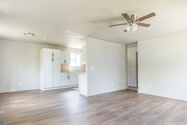 9114 Island Dr, Clay, MI 48001 - unfurnished living room with a sink, a ceiling fan, light wood finished floors, and baseboards