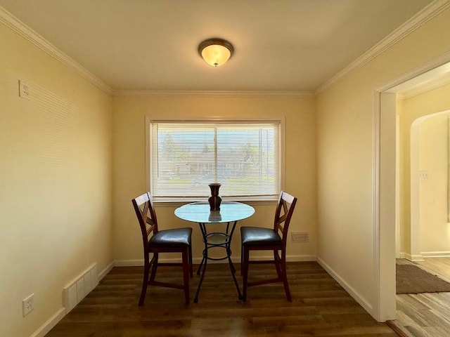 dining area with crown molding, visible vents, and wood finished floors