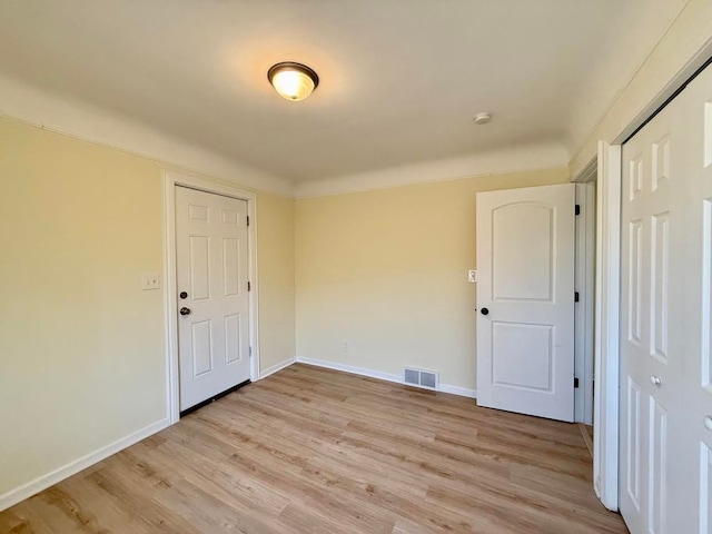 empty room featuring baseboards, visible vents, and light wood-style floors