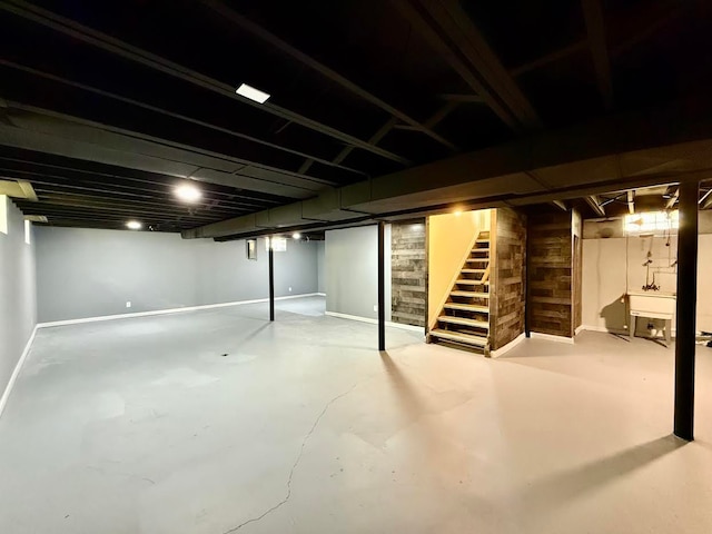 finished below grade area featuring stairs and baseboards