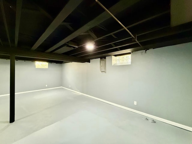 below grade area with electric panel, a wealth of natural light, and baseboards