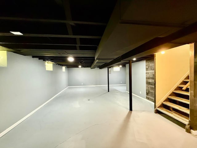 finished basement featuring stairs and baseboards