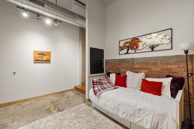 444 W Willis St Unit 204, Detroit, MI 48201 - carpeted bedroom featuring rail lighting, baseboards, and a high ceiling