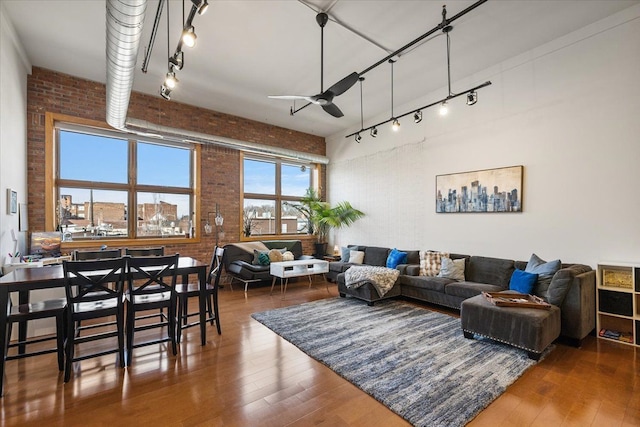 444 W Willis St Unit 204, Detroit, MI 48201 - living area with brick wall, rail lighting, a ceiling fan, and hardwood / wood-style flooring