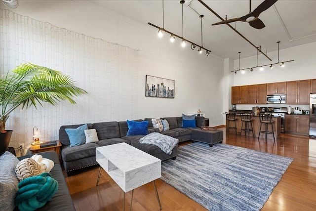 444 W Willis St Unit 204, Detroit, MI 48201 - living area featuring a ceiling fan, a high ceiling, wood finished floors, and rail lighting
