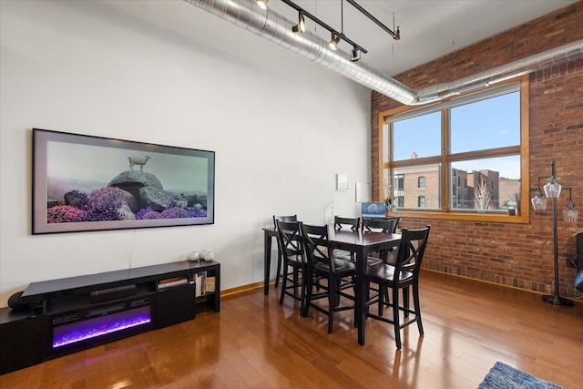 444 W Willis St Unit 204, Detroit, MI 48201 - dining area with brick wall, a high ceiling, and wood-type flooring