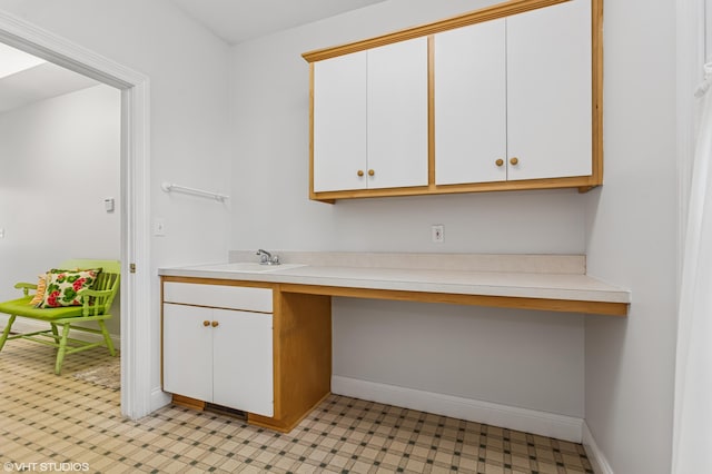 interior space featuring a sink, light floors, and baseboards