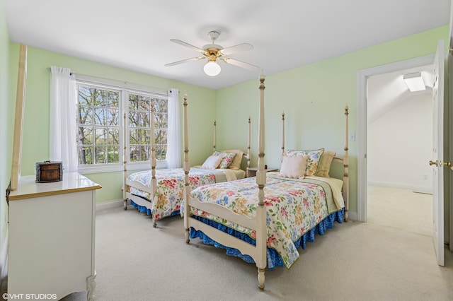 bedroom with a ceiling fan, baseboards, and light colored carpet