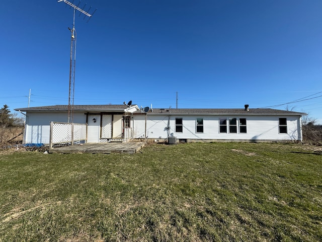 rear view of house featuring a patio, central AC unit, and a lawn
