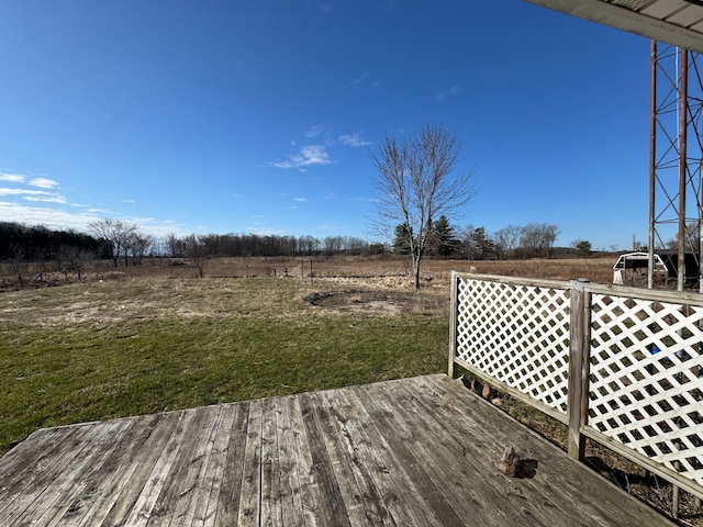 wooden terrace with a lawn and a rural view