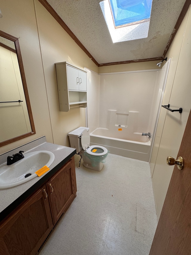 bathroom with toilet, shower / tub combination, vaulted ceiling with skylight, a textured ceiling, and vanity