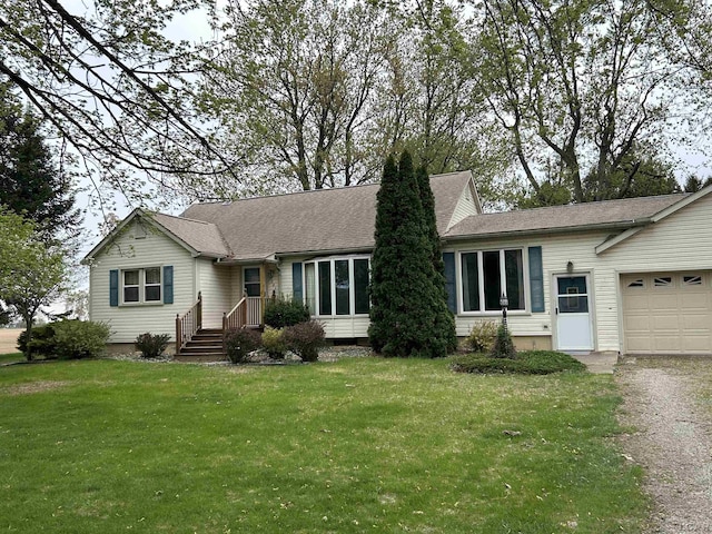 ranch-style house featuring a garage, a front lawn, and driveway