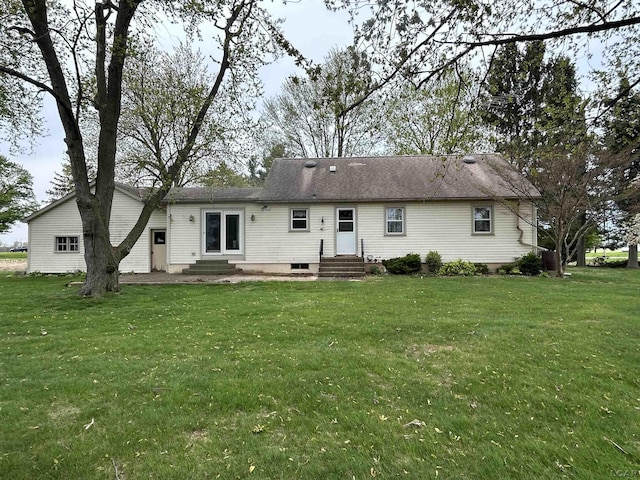 rear view of house featuring a yard and entry steps