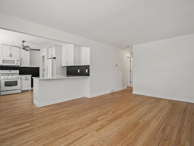 unfurnished living room featuring baseboards, light wood-type flooring, and a ceiling fan