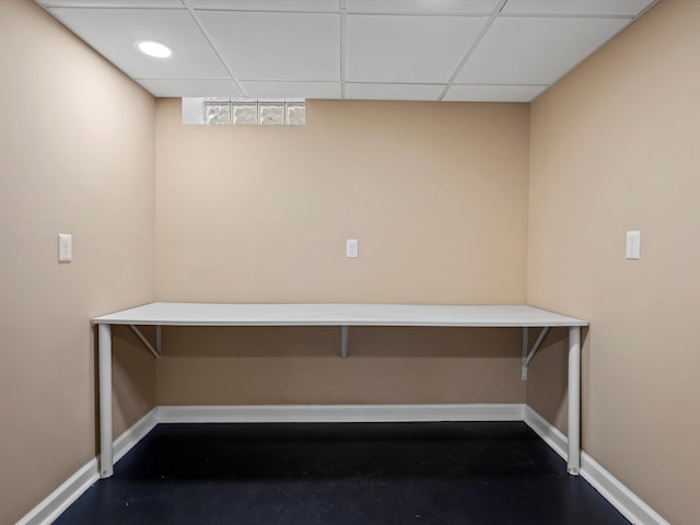 interior space with baseboards and a drop ceiling
