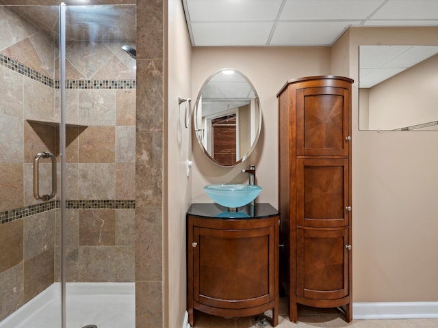 full bathroom with vanity, tile patterned floors, a shower stall, a drop ceiling, and baseboards