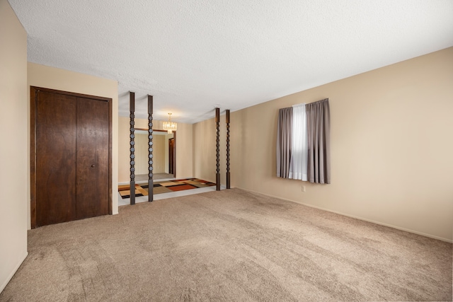 unfurnished room featuring carpet and a textured ceiling