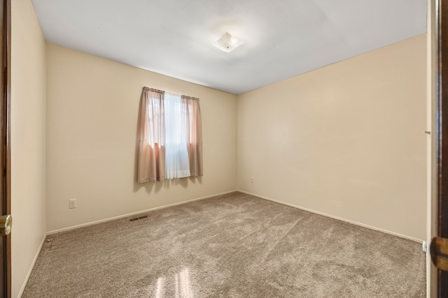 carpeted spare room featuring baseboards and visible vents