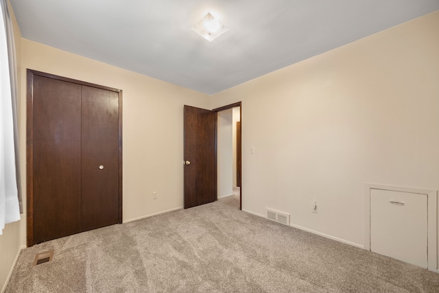 unfurnished bedroom featuring carpet, a closet, baseboards, and visible vents