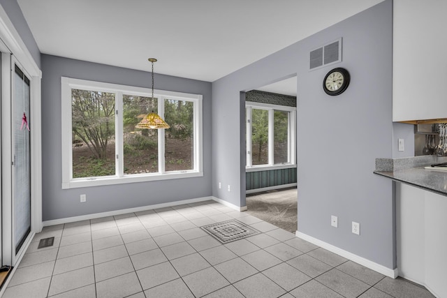 unfurnished dining area with visible vents, baseboards, and light tile patterned flooring