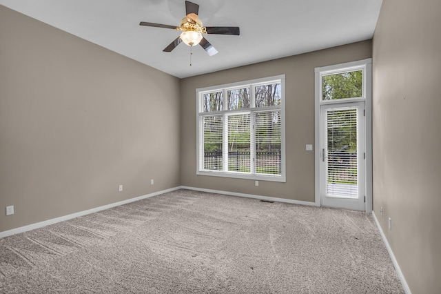 empty room with baseboards, ceiling fan, and carpet floors
