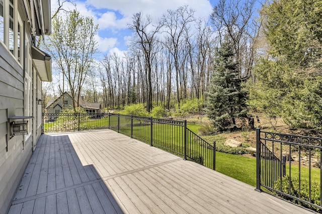 wooden deck featuring a lawn