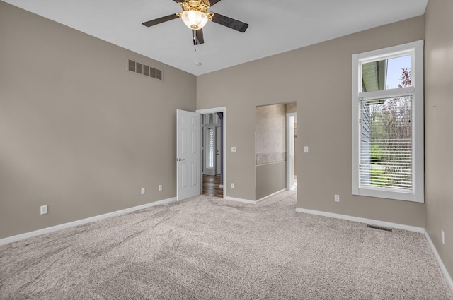 unfurnished bedroom with baseboards, a ceiling fan, visible vents, and carpet