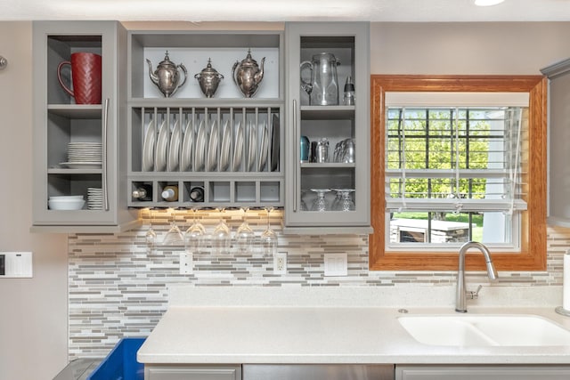 bar with a sink, decorative backsplash, and dishwashing machine