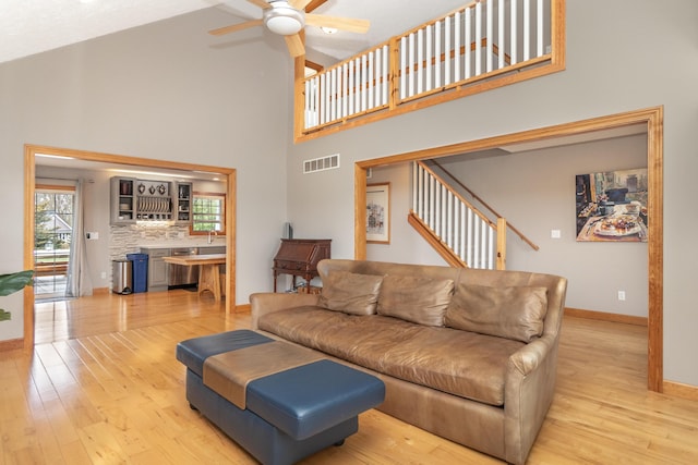 living area with ceiling fan, light wood-style flooring, baseboards, and visible vents