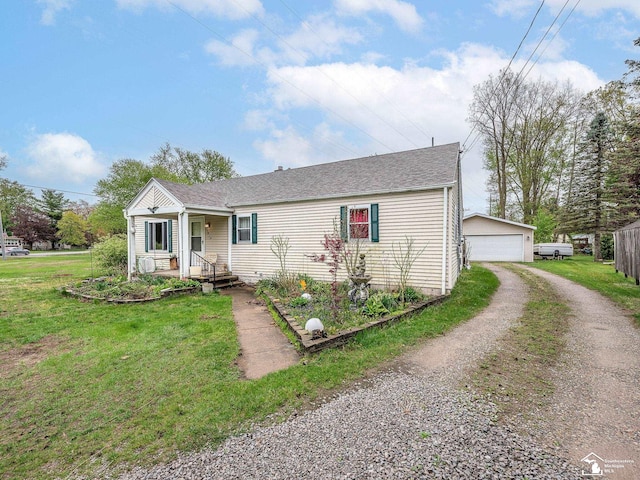 single story home featuring driveway, an outdoor structure, covered porch, a detached garage, and a front lawn